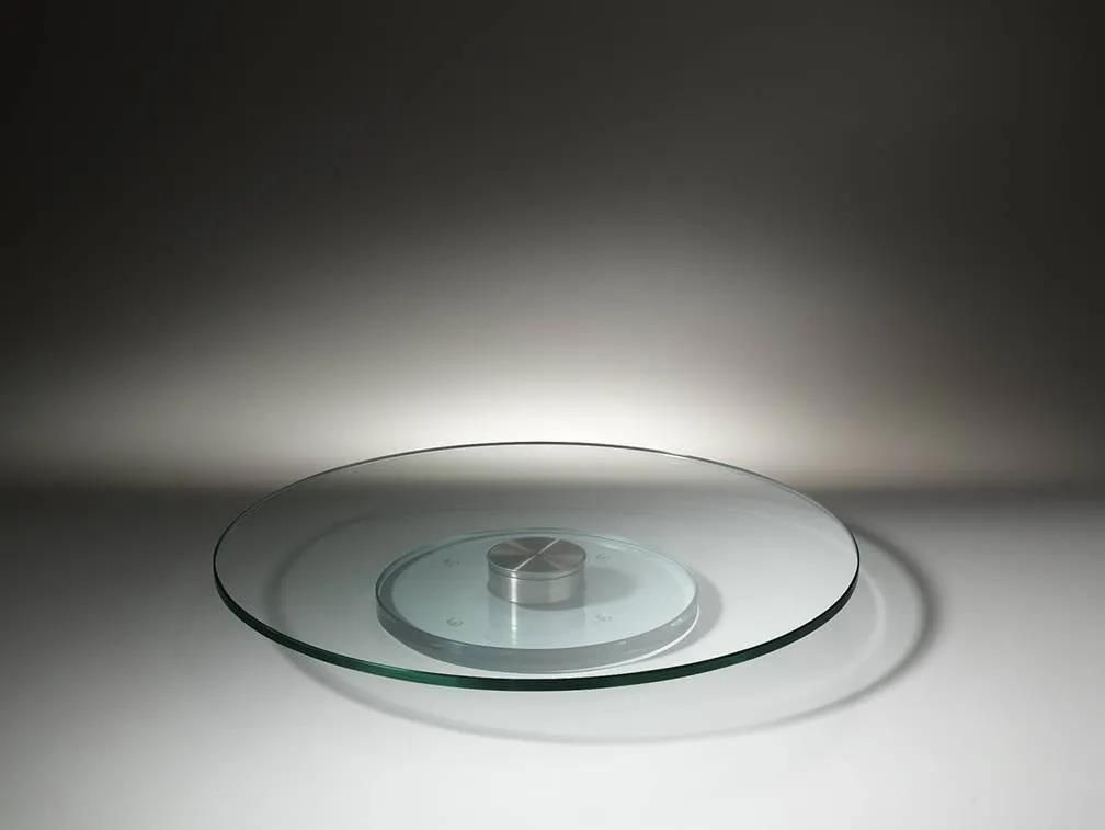 Eine Glasplatte mit Metallsockel liegt auf einem Tisch