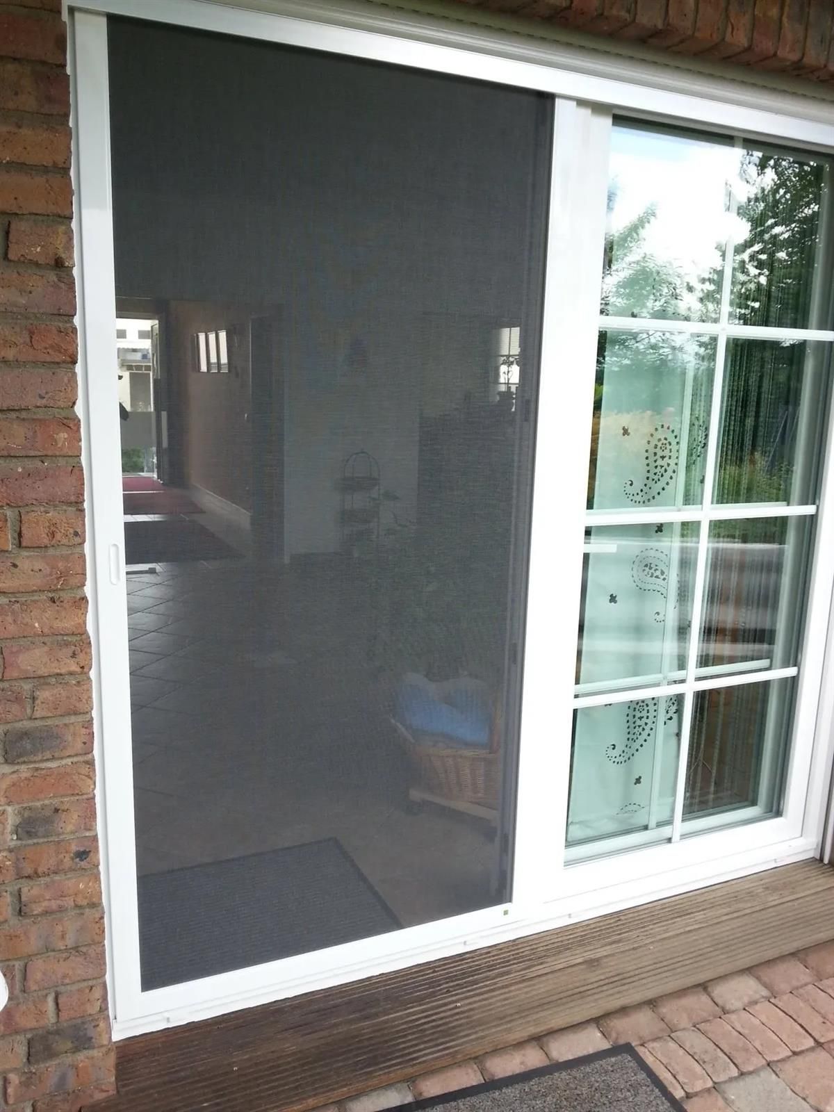 Eine Glasschiebetür mit einem Fliegengitter