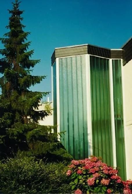 Ein Gebäude mit einem Baum und Blumen davor