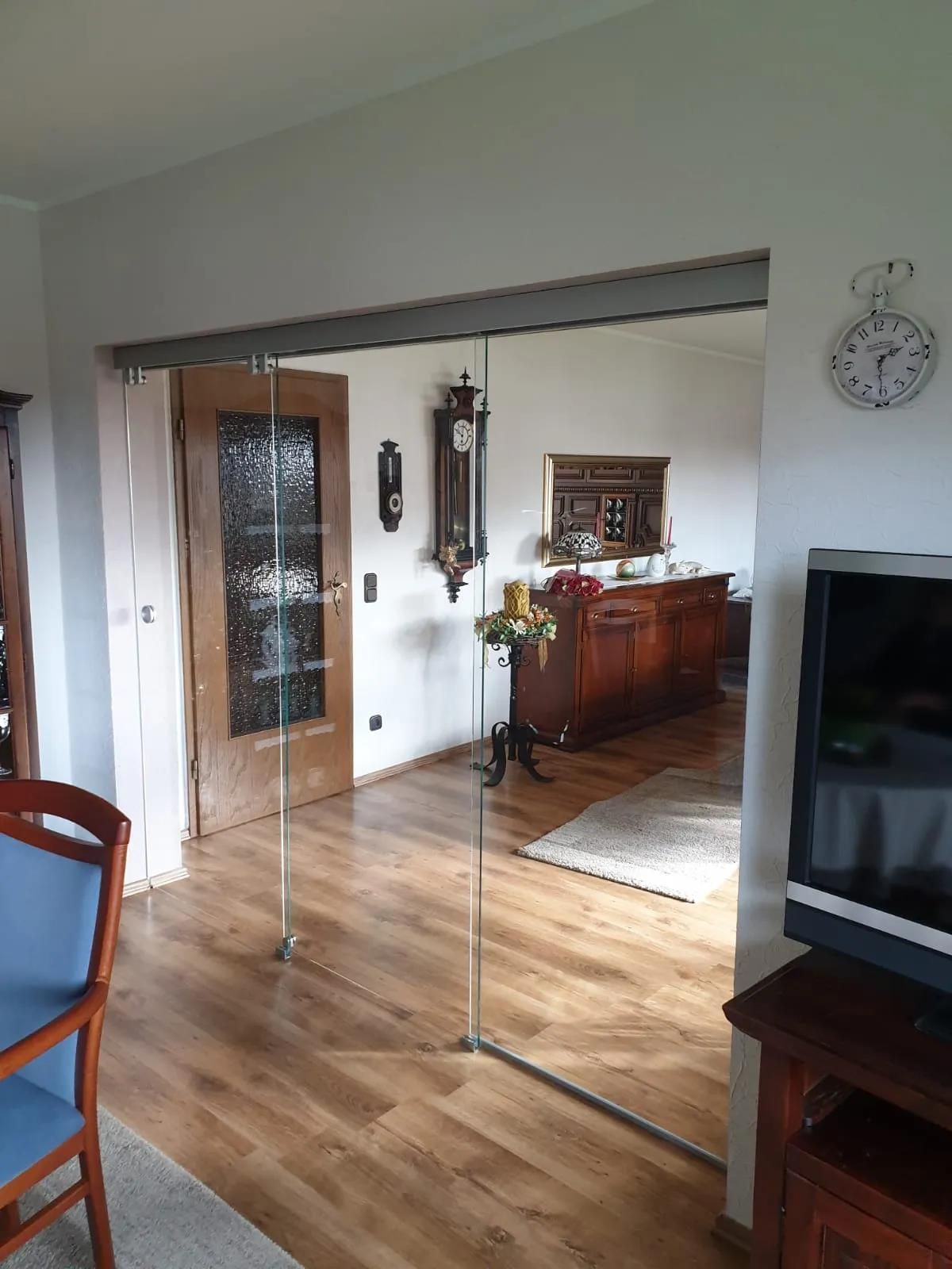 Ein Wohnzimmer mit Hartholzböden und einer Uhr an der Wand