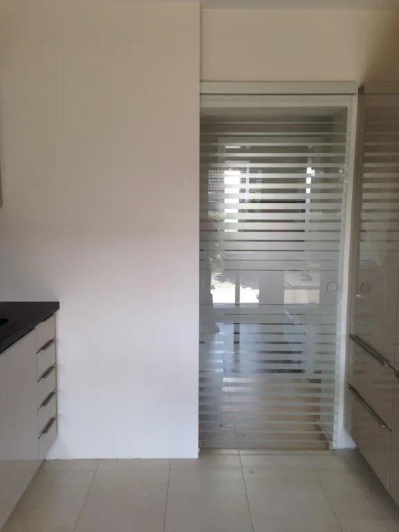 Eine Küche mit einer Glasschiebetür zwischen Küche und Badezimmer.