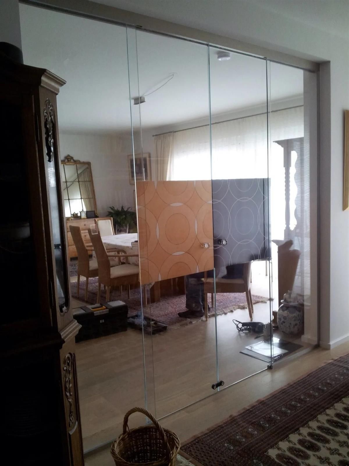 Ein Wohnzimmer mit Glasschiebetüren, die zum Esszimmer führen