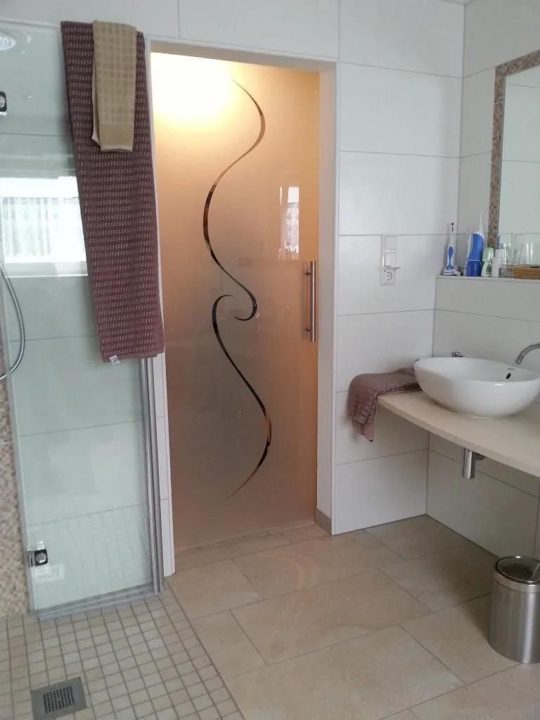 Ein Badezimmer mit Glasduschtür und Waschbecken