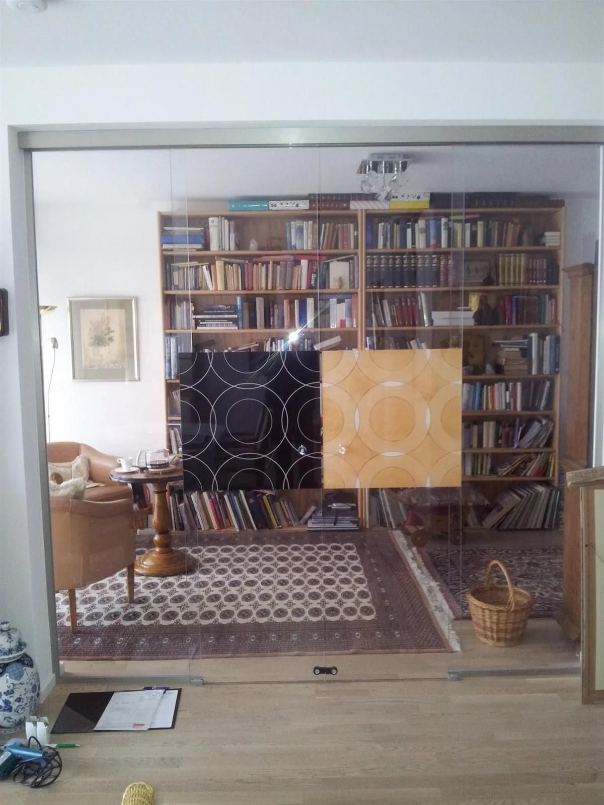 Ein Wohnzimmer mit vielen Bücherregalen und einem Teppich