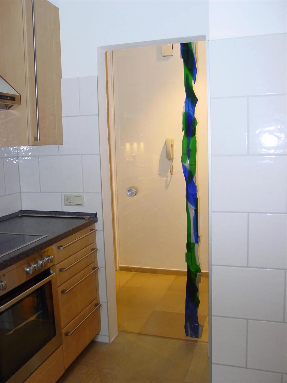 Eine Küche mit einer Tür, die zu einem Flur führt