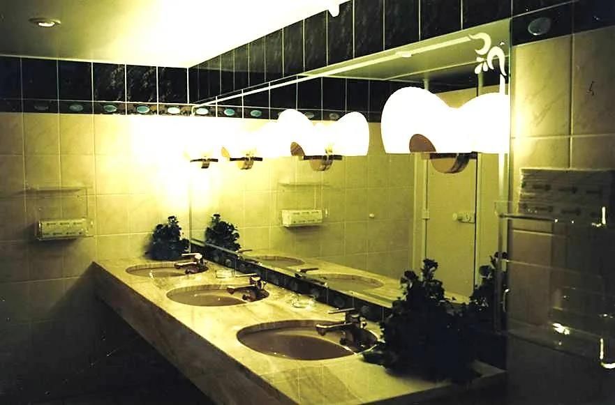 Ein Badezimmer mit einer Reihe von Waschbecken und einem großen Spiegel