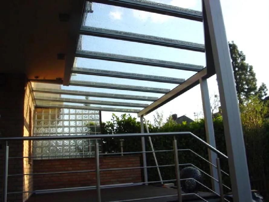 Ein Balkon mit Glasdach und Metallgeländer