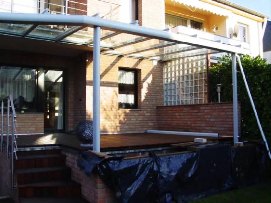 Ein Backsteinhaus mit einer glasüberdachten Veranda und Treppen