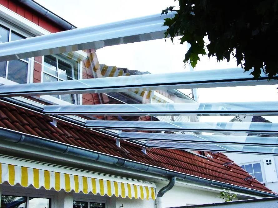 Ein Haus mit einem klaren Dach und einer gelb-weißen Markise