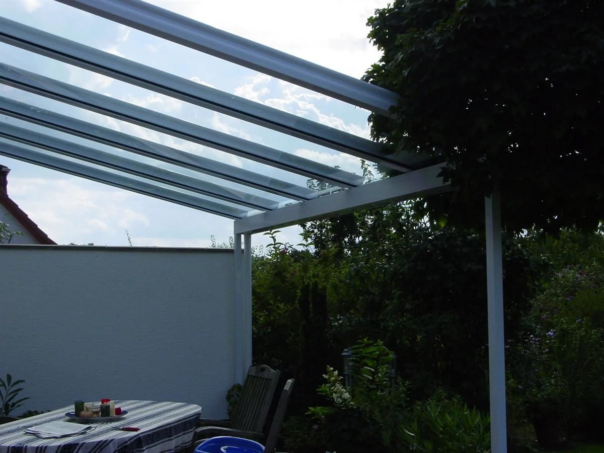 Eine Terrasse mit Tisch und Stühlen unter einem Baldachin