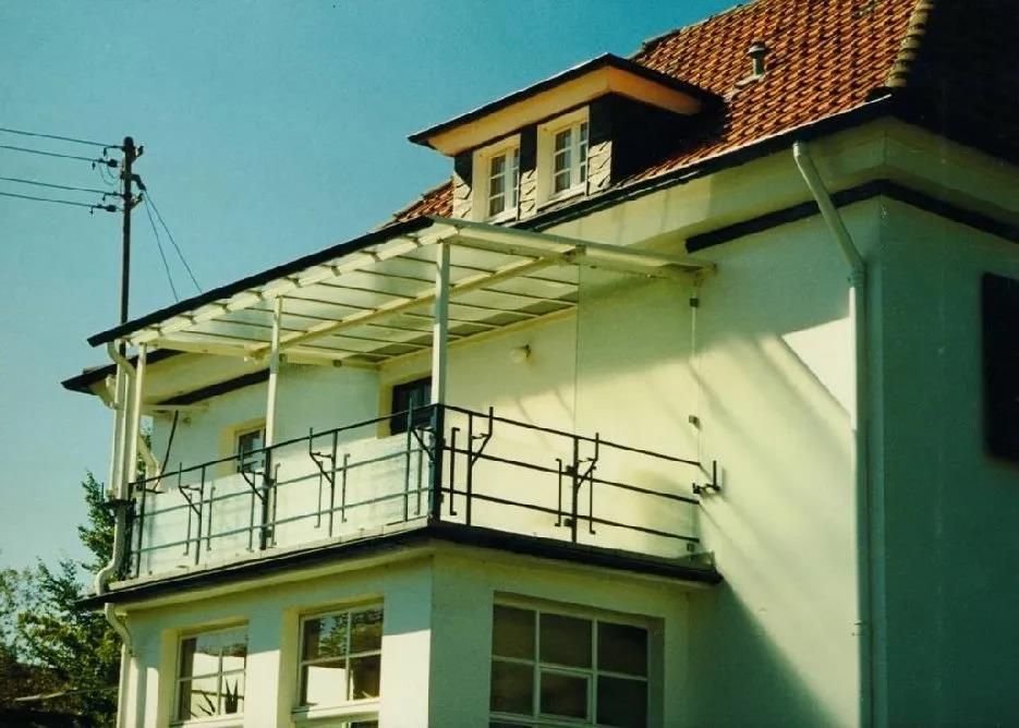 Ein weißes Haus mit Balkon und rotem Ziegeldach