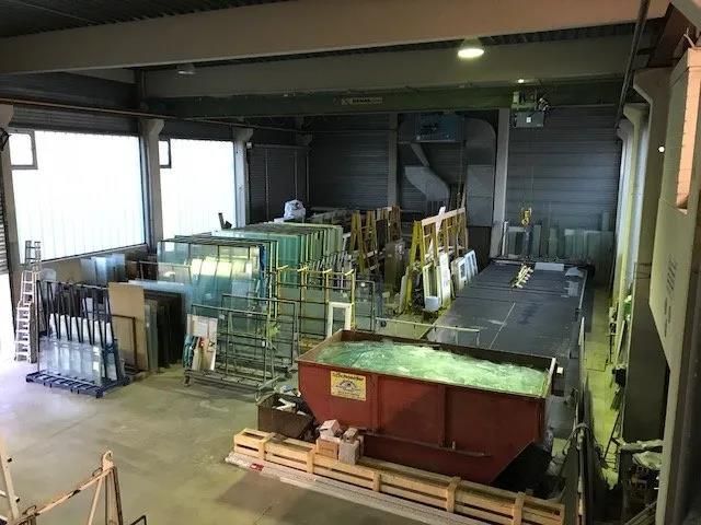 Ein großes Lagerhaus voller Glas und Maschinen.