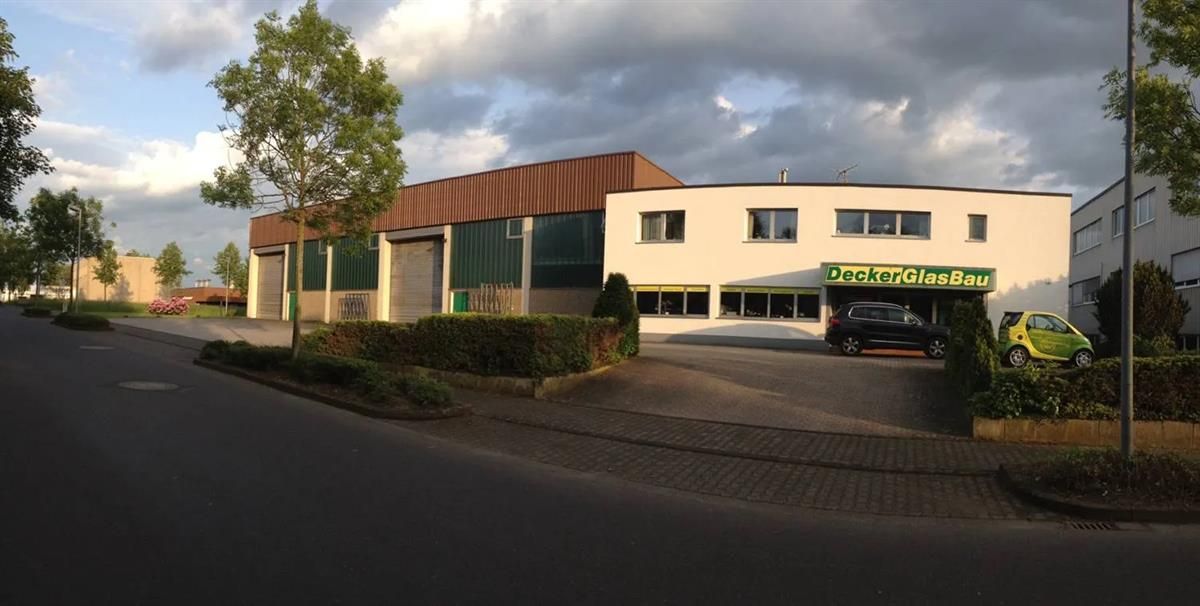 Ein großes weißes Gebäude mit einem grünen Schild mit der Aufschrift „Präzision“