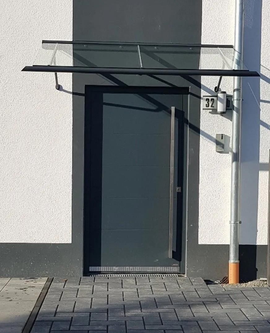 Eine schwarze Tür mit einem Glasdach darüber