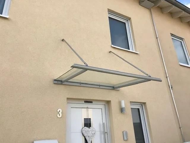 Ein Haus mit einem Vordach über der Tür und der Nummer 3