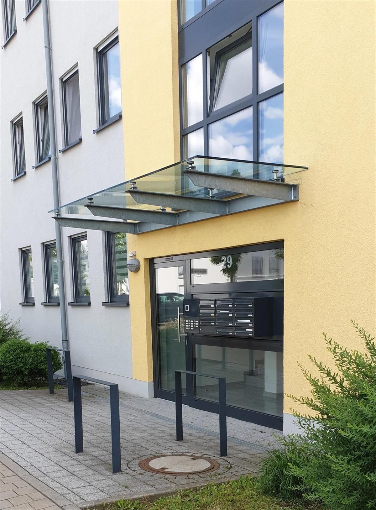 Ein gelbes Gebäude mit einem Glasdach über dem Eingang