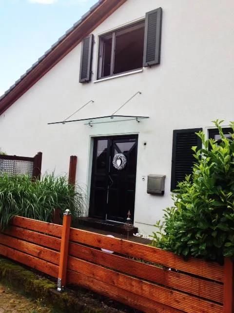 Ein weißes Haus mit einem Holzzaun davor