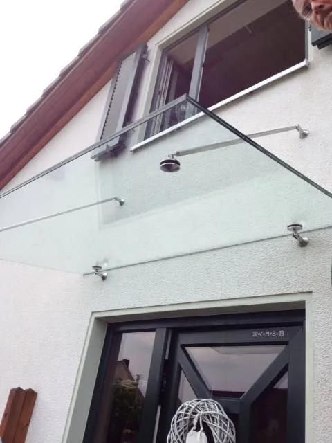 Ein weißes Haus mit einem Glasdach über der Tür