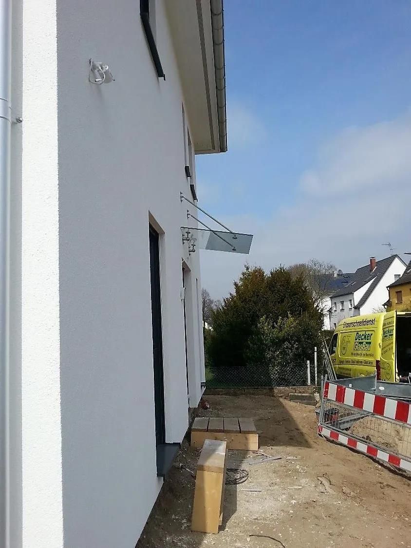 Ein weißes Gebäude mit einem gelben Lieferwagen im Hintergrund, auf dem 