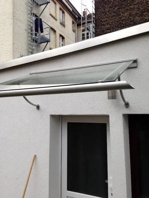 Ein weißes Gebäude mit einem Vordach über einer Tür