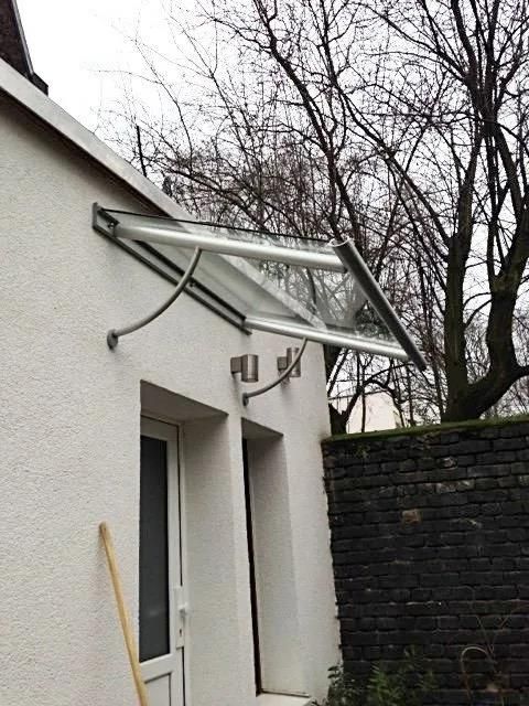 Ein weißes Gebäude mit einem Vordach über der Tür.