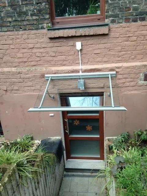 Ein Backsteingebäude mit einem Glasdach über der Tür.