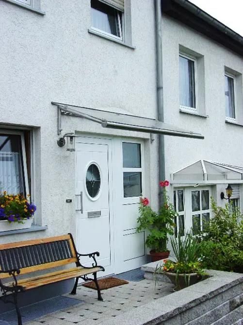 Ein weißes Haus mit einer Bank davor