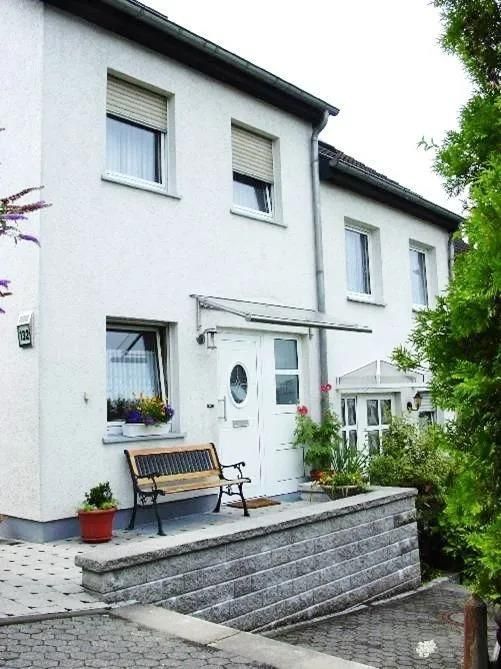 Ein weißes Haus mit einer Bank davor