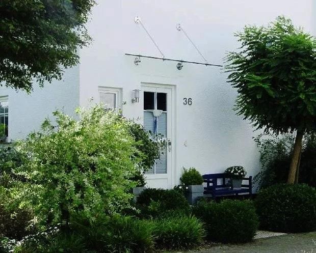 Ein weißes Haus mit der Nummer 36 an der Eingangstür