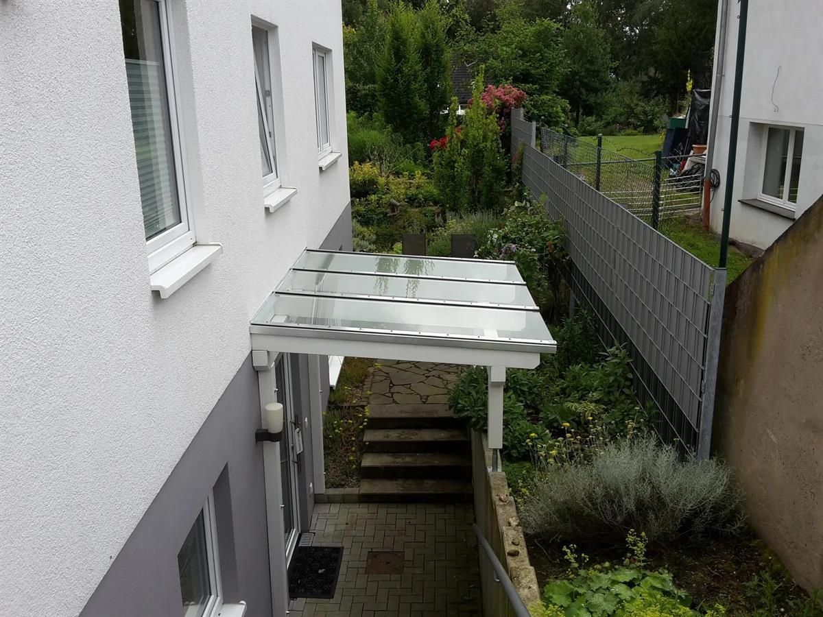 Ein weißes Gebäude mit einem Glasdach über dem Eingang