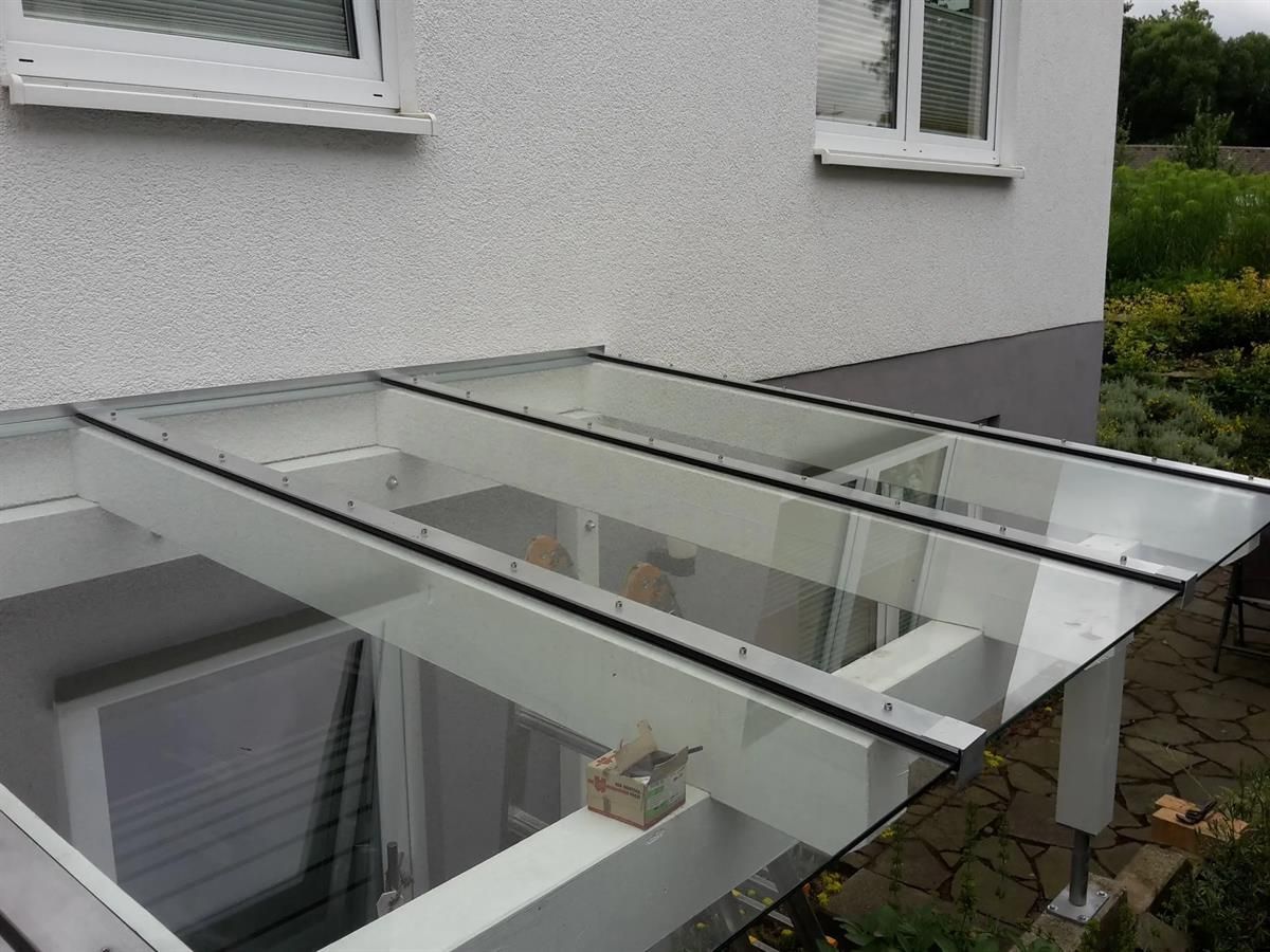 Ein weißes Haus mit einem Glasdach an der Seite