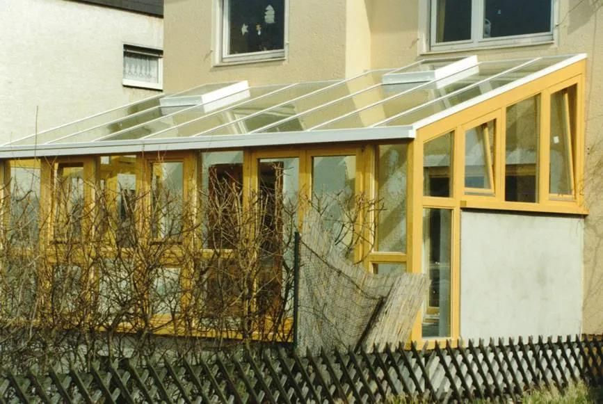 Ein Haus mit einem Glasdach und einem Zaun darum