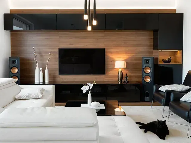 Sala de estar moderna con paneles de madera, detalles en negro, sofá blanco y centro de entretenimiento.