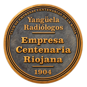 Medallón redondo de bronce con la inscripción «Empresa Centenaria Riojana» y «1904».