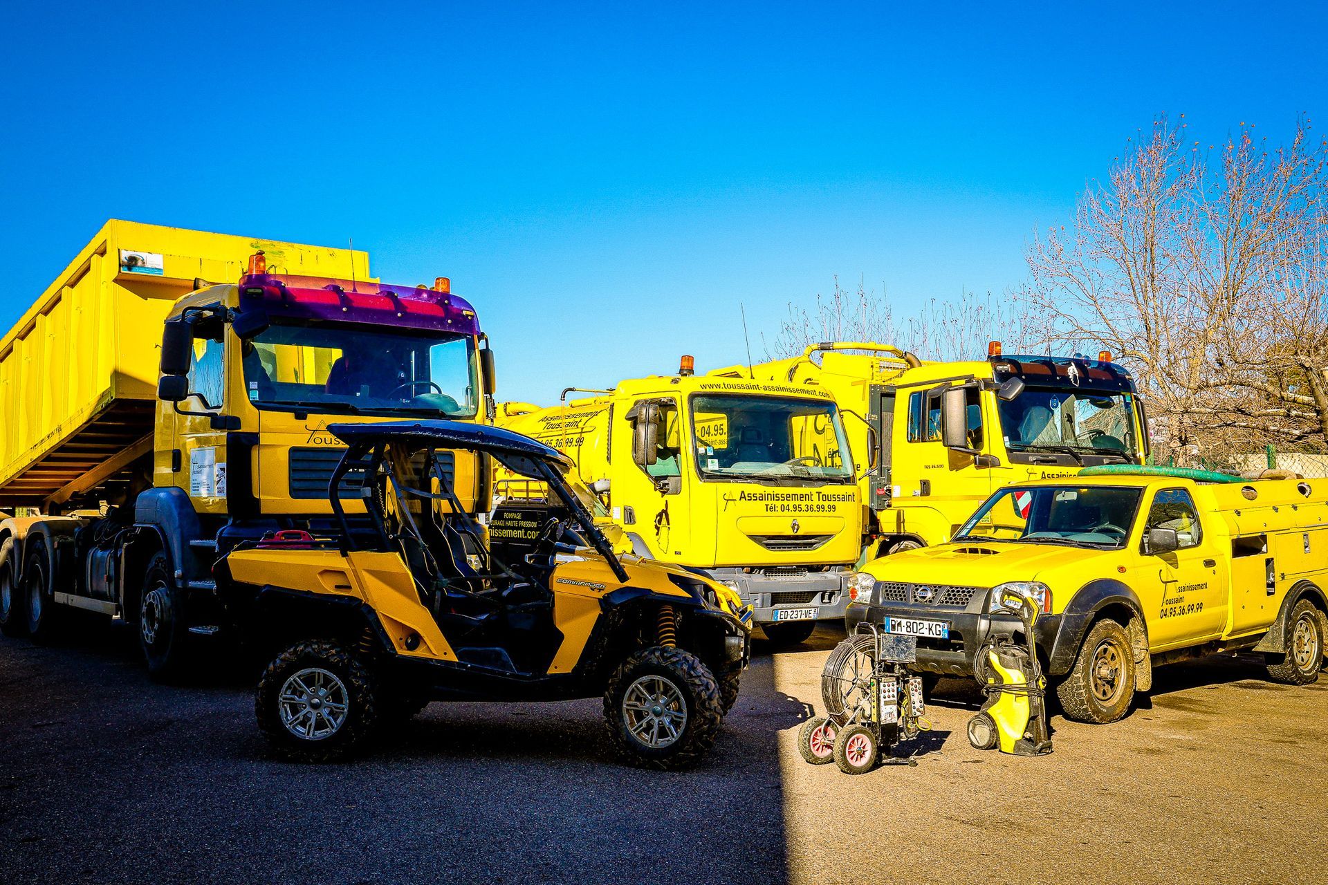 Des camions et un petit véhicule jaune.