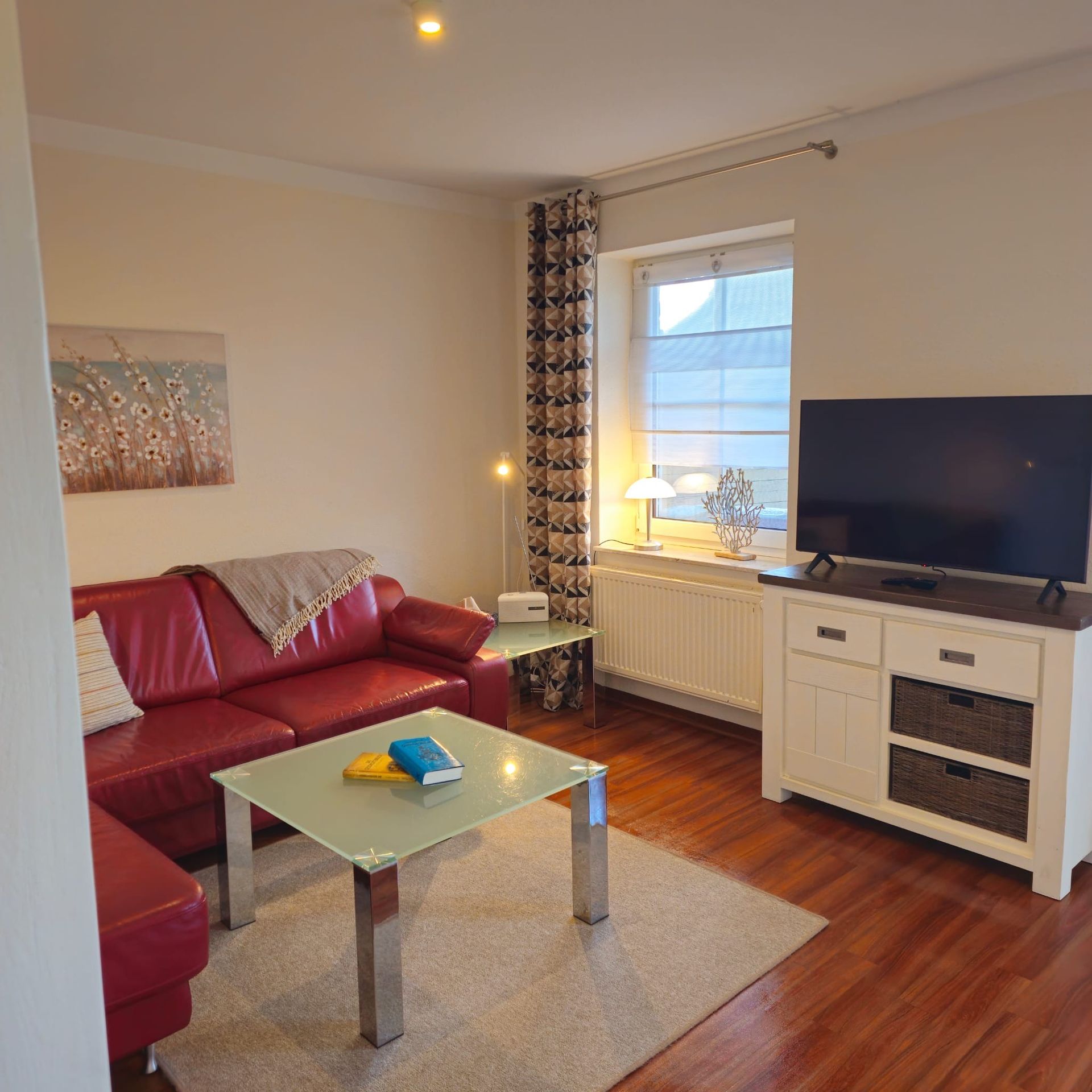 Ein Wohnzimmer mit einem roten Sofa und einem Flachbildfernseher