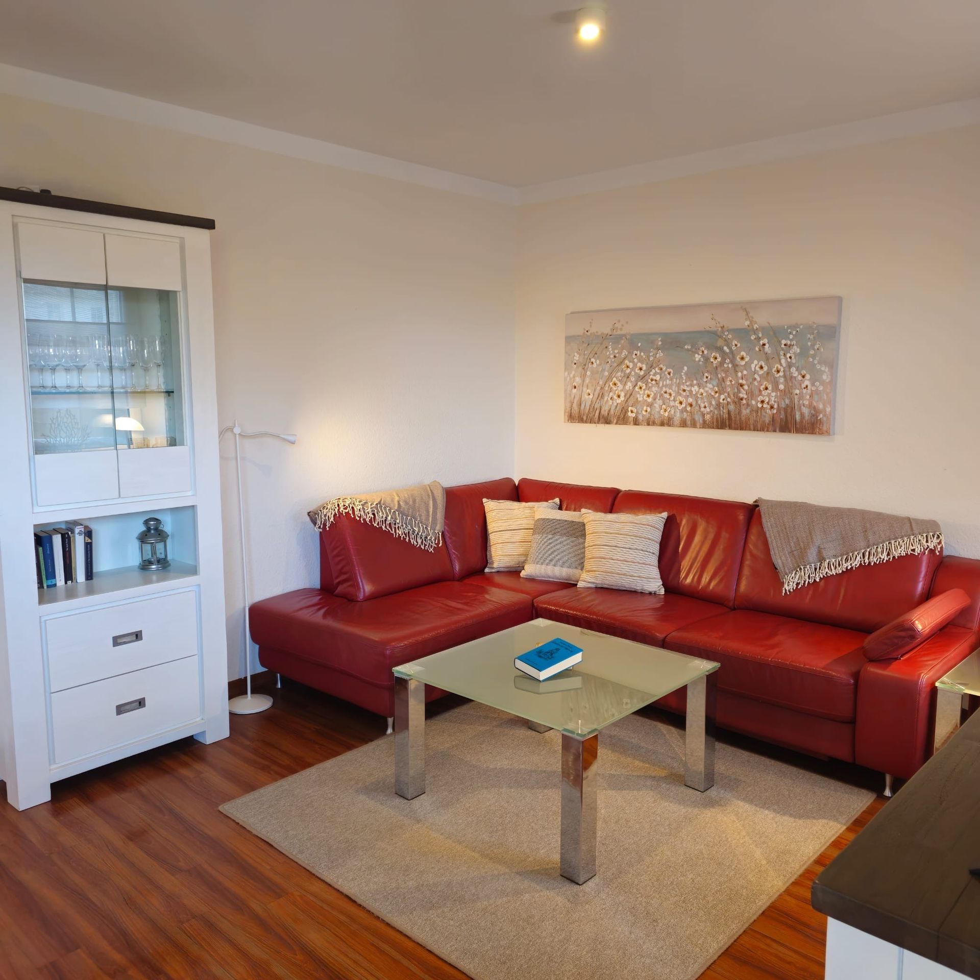 Ein Wohnzimmer mit einer roten Couch und einem Couchtisch