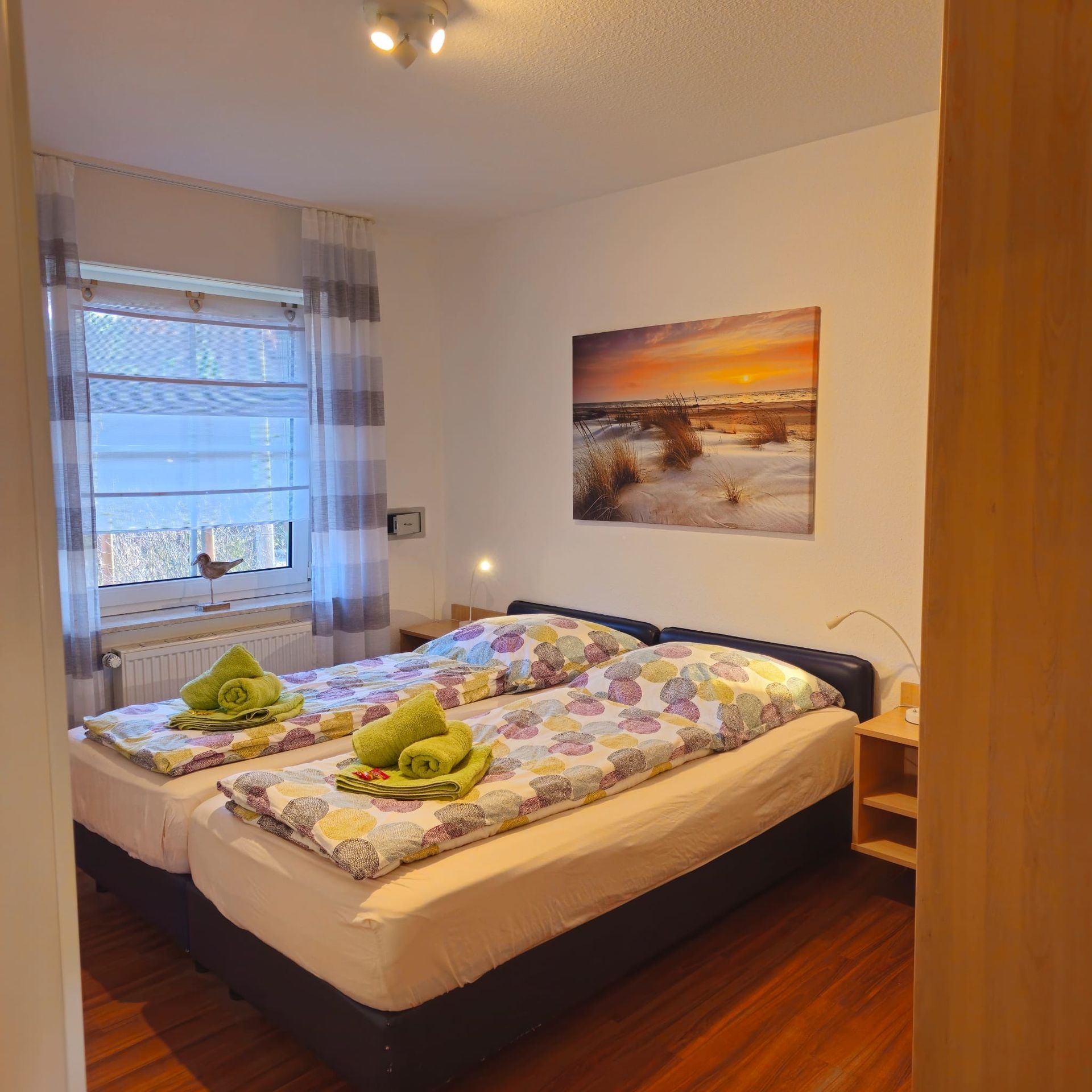 Ein Schlafzimmer mit zwei Betten und einem Gemälde an der Wand