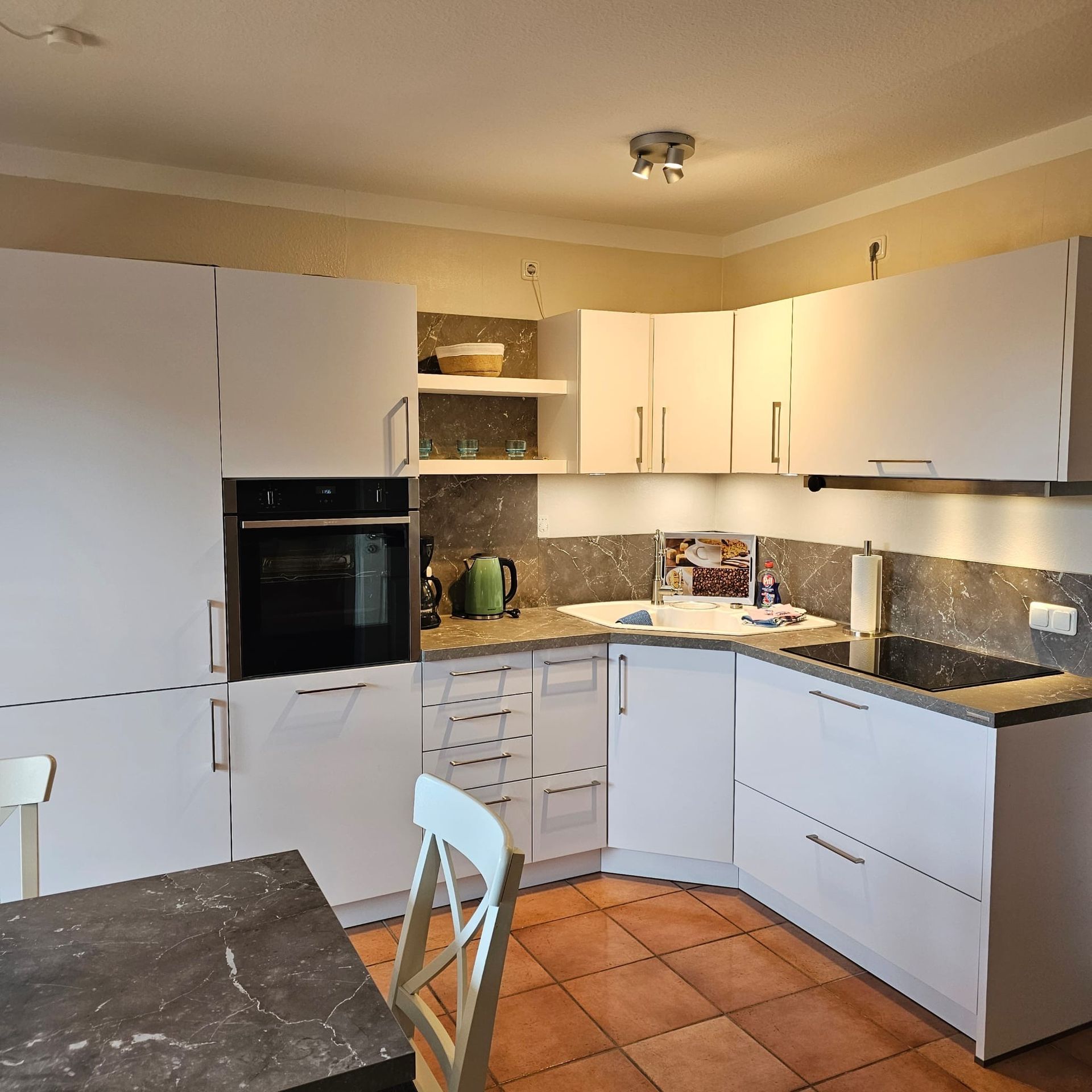 Eine Küche mit weißen Schränken und einem Herd mit Backofen