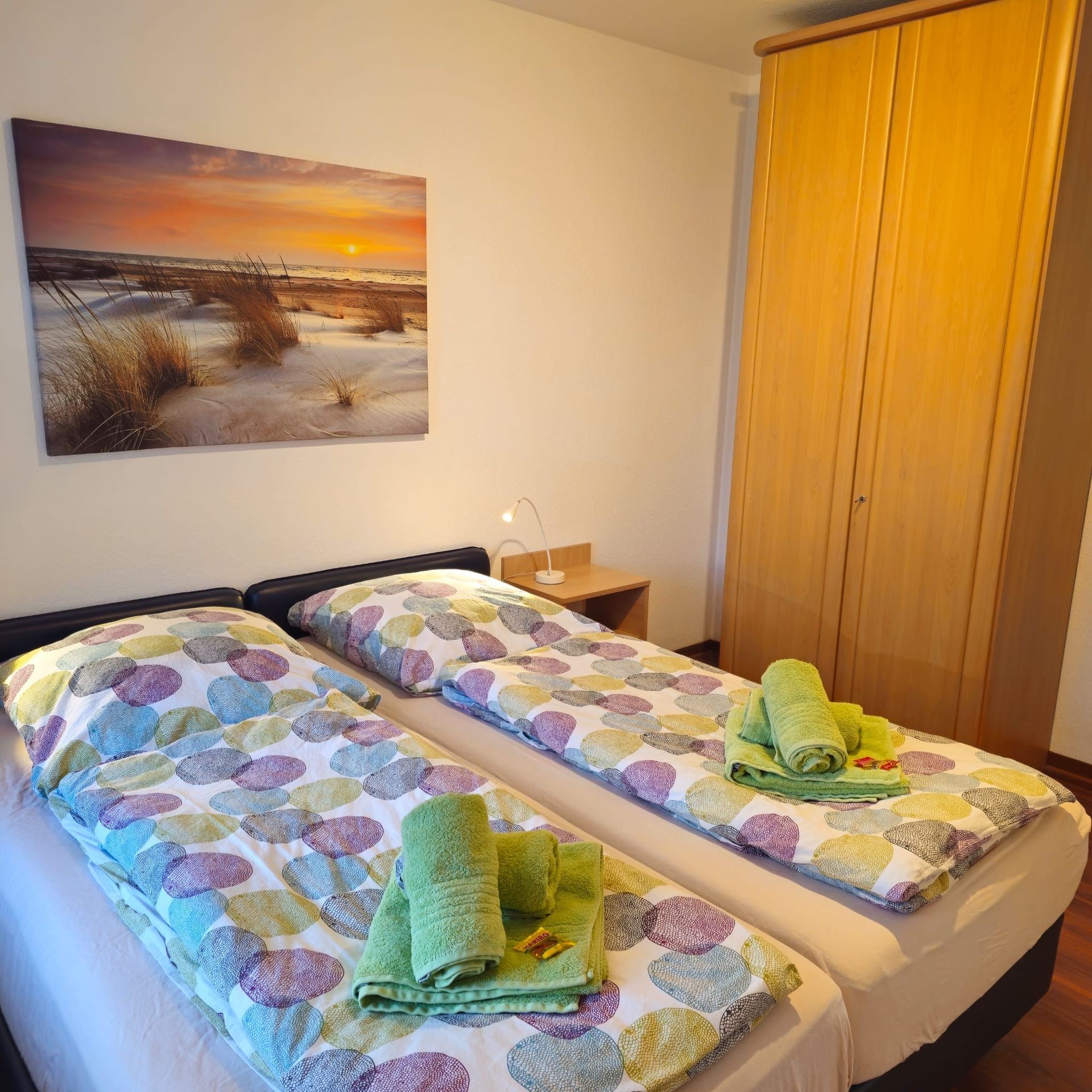 Ein Schlafzimmer mit zwei Betten und einem Gemälde an der Wand