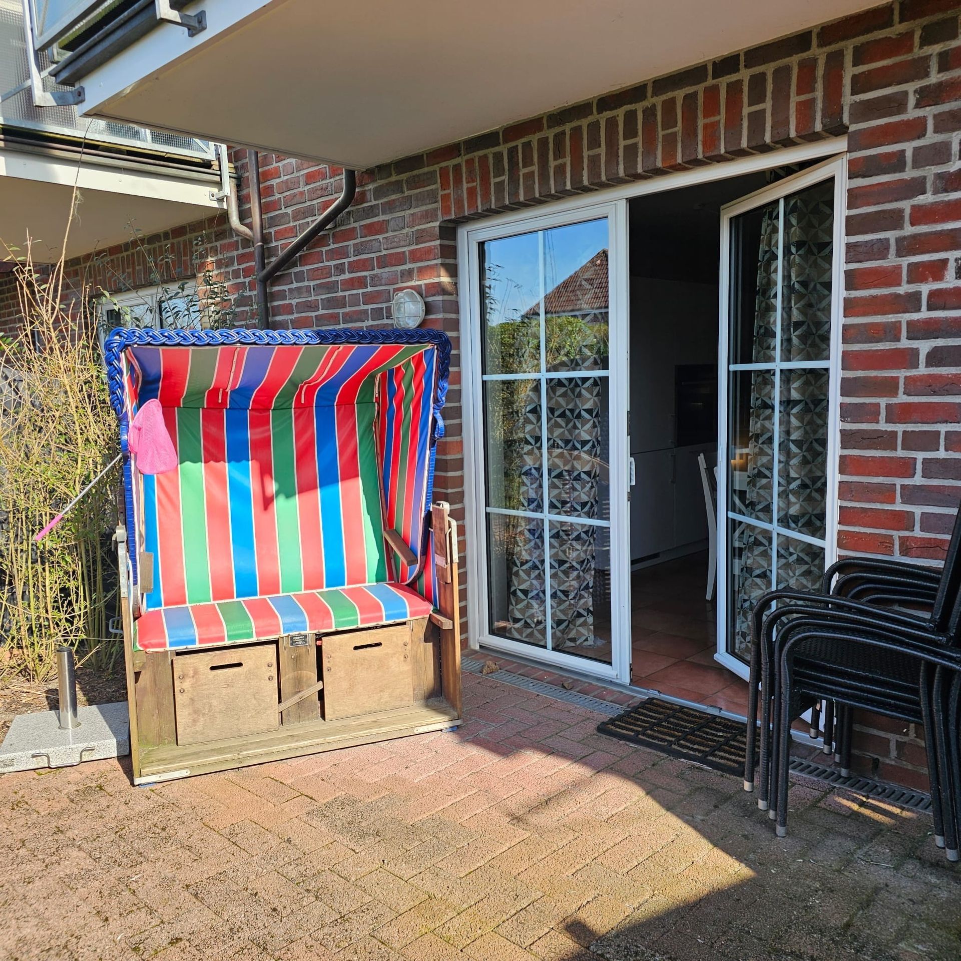 Ein gestreifter Stuhl steht vor einem Backsteingebäude