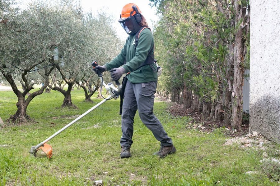 Une personne qui débroussaille un jardin