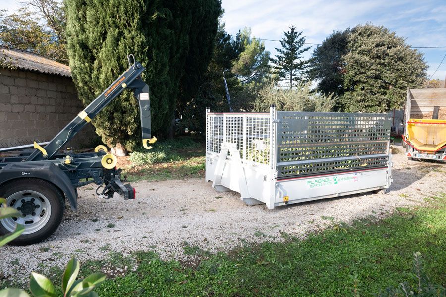 Benne à feuilles posée sur des graviers