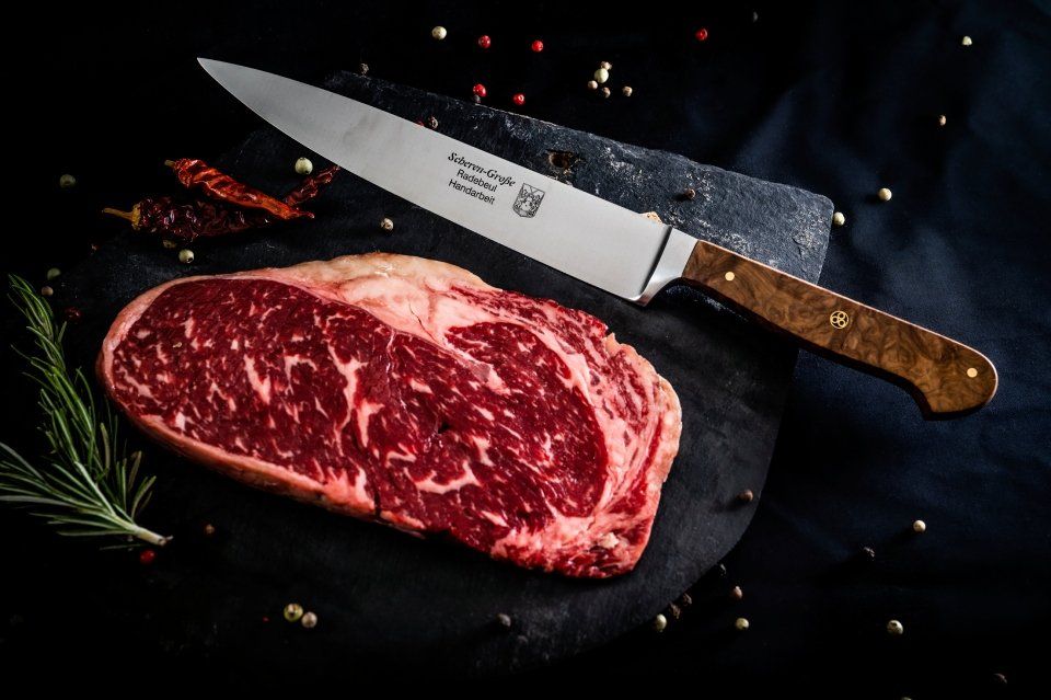 Schleiferei Scheren-Große – Messer neben einem Stück Fleisch