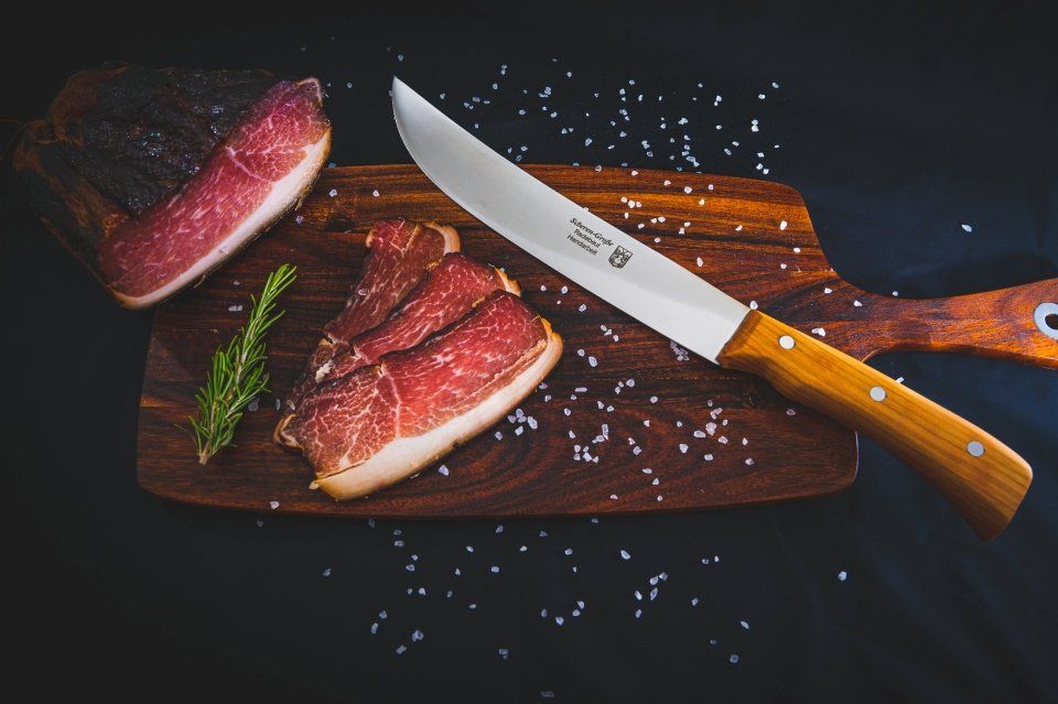 Schleiferei Scheren-Große – Messer neben Fleisch auf einem Schneidebrett