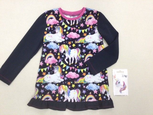 Schwarzes Langarmshirt mit Einhorn-Print, Rüschensaum und passendem Etikett, farbenfrohes Design auf weißem Hintergrund.