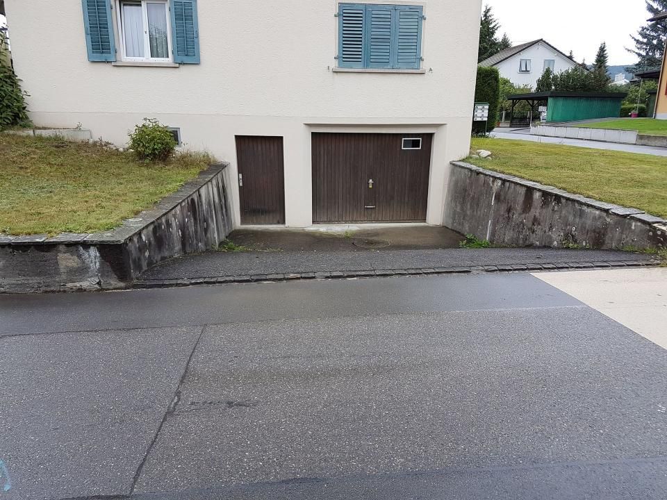 Die Hauseinfahrt mit steilen Betonrampen führt von der Strasse zum Garageneingang.
