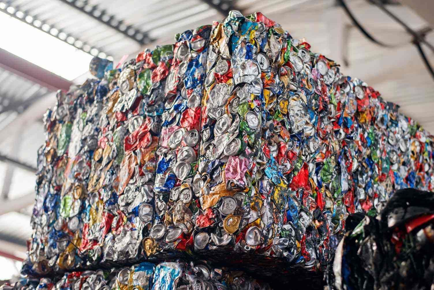 Bloque comprimido de latas de aluminio trituradas apiladas en una planta de reciclaje.