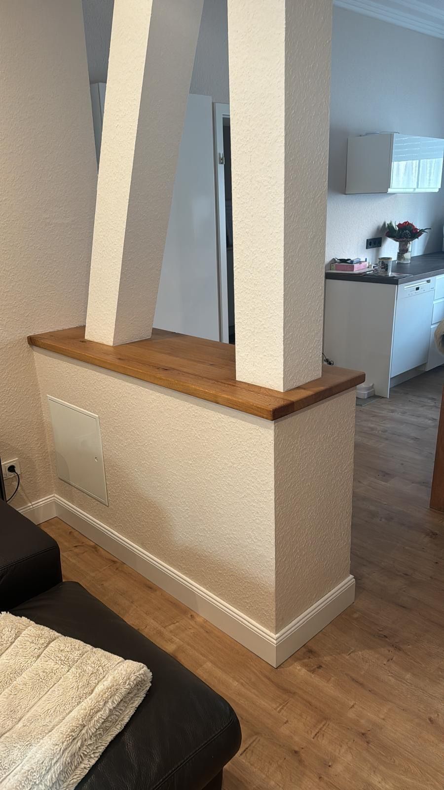 Raumteiler mit zwei weißen Säulen, darauf eine hölzerne Arbeitsplatte.