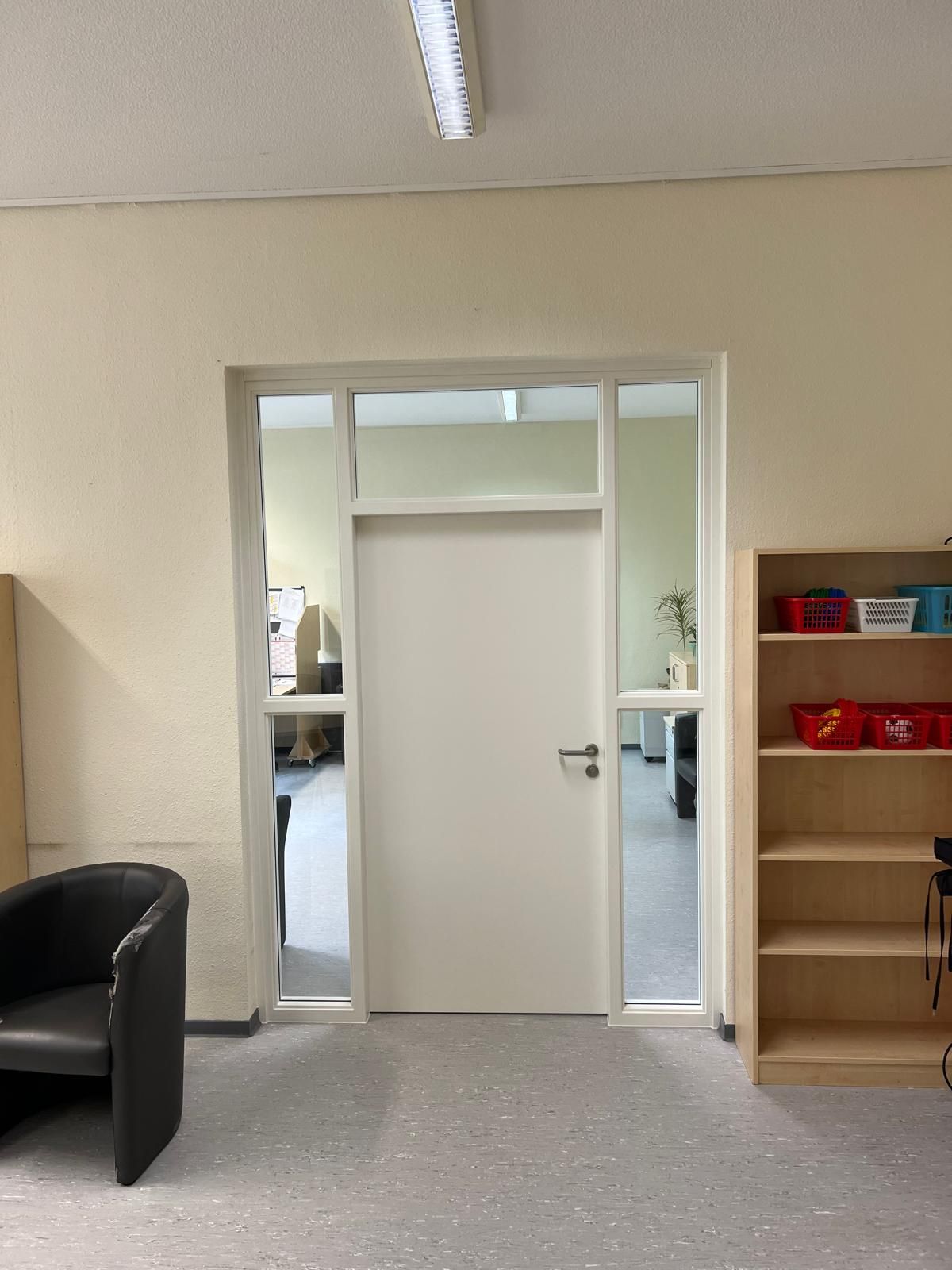 Eine Werkstattszene mit einer Trittleiter, großen weißen Paneelen und einer Säge.